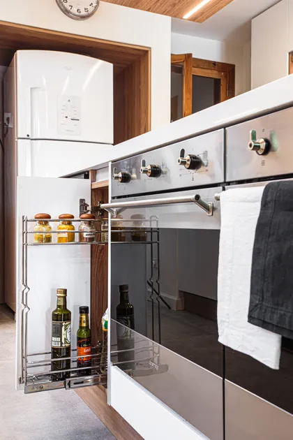 Cocina contemporánea blanca con muebles de madera y electrodomésticos integrados — proyecto Casa Nordelta, por Gutman+Lehrer Arquitectas, en Nordelta