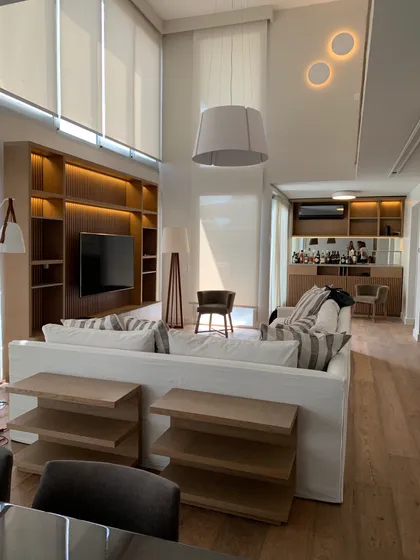 Living moderno con doble altura, sofá blanco y estanterías integradas — proyecto Piso en Nuñez, por Gutman+Lehrer Arquitectas, en Núñez