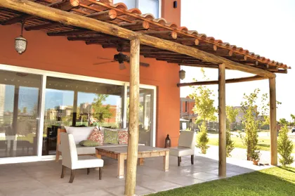 galería exterior con pérgola de madera y techo con tejas — proyecto Los Alisos, Nordelta, por Marconi Silva Arquitectos, en Los Alisos