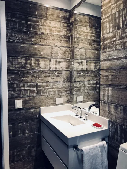 Baño moderno con pared de madera oscura y vanitory blanco — proyecto Nordelta , por Greschek Obras , en Nordelta