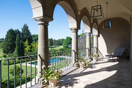 Terraza clásica con columnas, arcos y vista a jardín con pileta — proyecto Casa Toscana , por Estudio Du 
