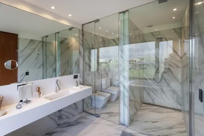 baño moderno con mármol y doble lavabo — proyecto Casa BJM, por Vanguarda Arquitectos, en Belén de Escobar