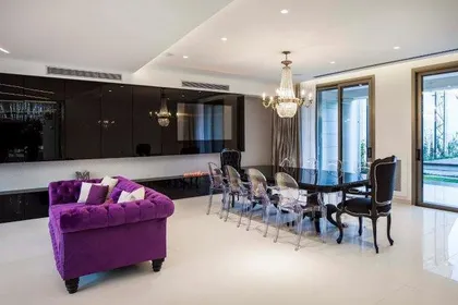 Living comedor moderno con sofá curvo y araña de cristal — proyecto Casa PMorán, por Vanguarda Arquitectos, en CABA