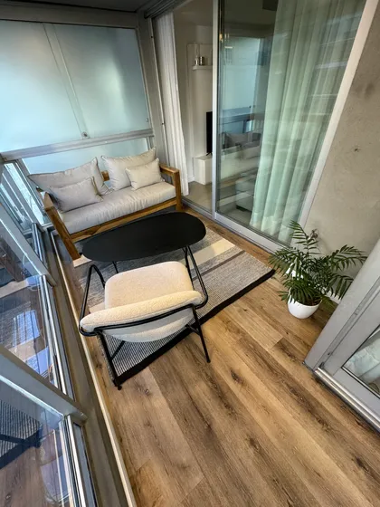 Balcón moderno con sofá, sillón y planta — proyecto Salguero I, por MDBK Arquitectura, en Palermo
