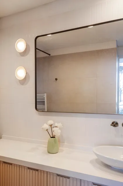 Baño moderno con luces de cristal, espejo grande y vanitory de madera acanalada — proyecto Highland, por Lala Loviscek arquitecta, en Pilar