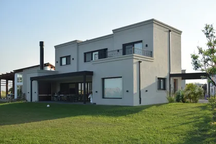 Casa moderna de dos pisos con amplios ventanales y patio exterior — proyecto Casa CG191, por EZ architects, en Belén de Escobar