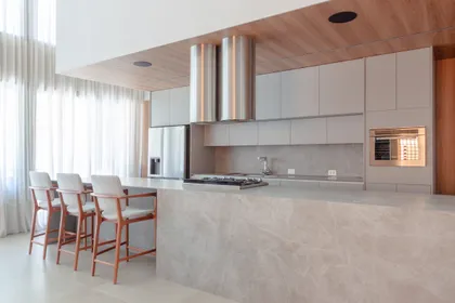 Cocina moderna de doble altura con isla grande y techo de madera — proyecto Garden E.A., por Bauha Arquitetura, en Curitiba