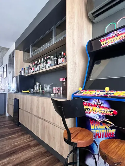 Cocina moderna con barra y máquina arcade temática — proyecto Proyecto 60, por Momas Interiores, en La Plata