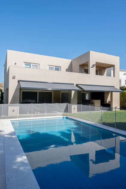 Casa moderna con piscina y toldos retráctiles — proyecto Campo grande IV, por Juarez-Fevre Estudio de Arquitectura , en Buenos Aires