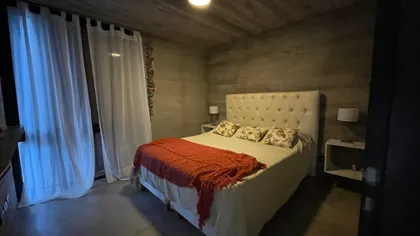 Dormitorio industrial moderno con paredes de hormigón y techo de madera — proyecto Casa R2, por Guerrero Arquitectos, en Pinamar