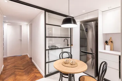 Cocina y comedor modernos con isla y luz colgante negra — proyecto Libertad, por Estudio Basa, en Buenos Aires