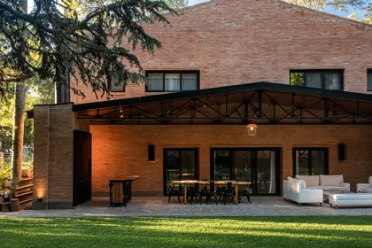 Fachada moderna con patio amplio y mobiliario exterior — proyecto Loft y garage autos de colección , por Arq. Damian Fainzilber, en San Isidro