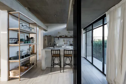 Cocina moderna con isla, estanterías abiertas y vistas al exterior — proyecto CASA JOTA, por arquitectura.JD, en La Plata