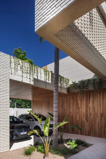 Fachada moderna con jardín vertical y revestimiento de madera — proyecto Casa Magnolia, por Estudio PK, en San Isidro
