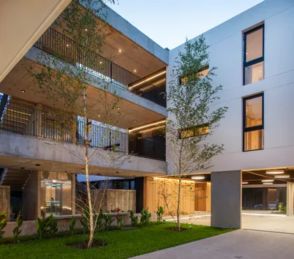 Fachada moderna de edificio de apartamentos con balcones y vegetación — proyecto Alvear AV, por V2 Arquitectos, en City Bell