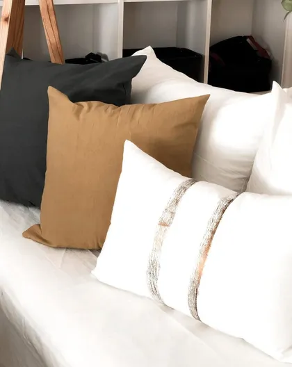 Cojines neutros apilados en cama, estilo nórdico — proyecto Las Heras , por Claraboia , en Recoleta