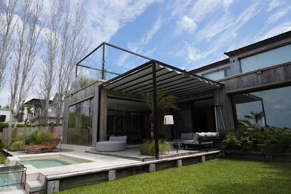 fachada moderna de madera con pérgola y piscina — proyecto TOLDER - PERGOLAS, por Argentina en Obra 2024, en Rincón de Milberg