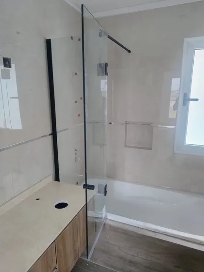 Baño moderno minimalista con bañera exenta y ducha de cristal — proyecto Mampara paño fijo + rebatible , por Cristalcenter, en Belén de Escobar