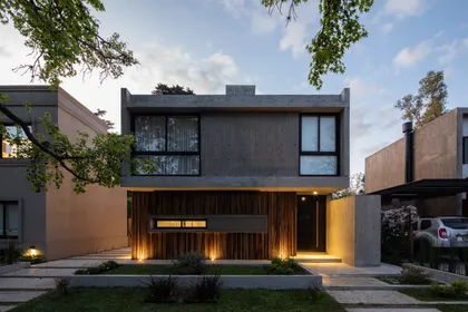 Fachada moderna de hormigón y madera con iluminación integrada — proyecto Casa Emilia, por Grupo CRBN, en Parque Leloir