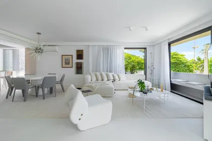 Amplio living comedor blanco con sofa curvo modular y vistas tropicales — proyecto Residencial, por Rodolfo Fontana