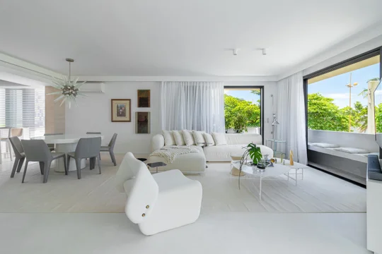 Amplio living comedor blanco con sofa curvo modular y vistas tropicales — proyecto Residencial, por  Rodolfo Fontana