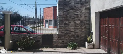 Fachada de casa con revestimiento de piedra y portón de madera — proyecto Refacción de vivienda/ reparaciones, por Gastón Argüello construcciones, en Córdoba