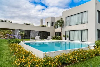 Moderna casa blanca con piscina y flores amarillas — proyecto trv 427, por Estudio Arq Daniel Tarrio