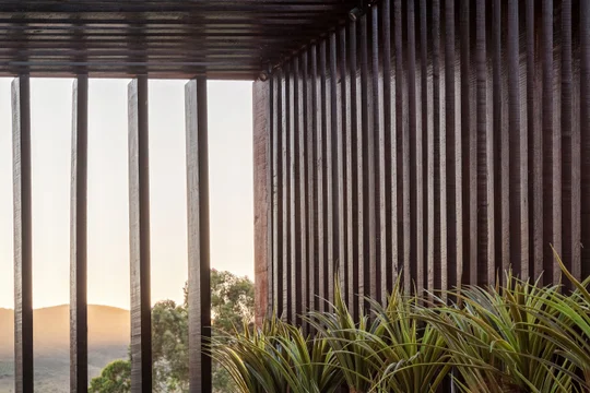 Terraza moderna con pérgola de hierro negro, plantas y vista montaña — proyecto CASA RR, por Frederico Bicalho Arquitetura