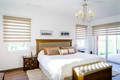 Dormitorio clásico con cama king y detalles ornamentados — proyecto La casa del árbol, por Estudio Fernandez Long & asoc., en Canning