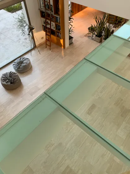 Living de doble altura con estanterías y luz natural — proyecto CASA LR 56 - SOFITEL LOS CARDALES  , por Carolina Depetris, en Los Cardales