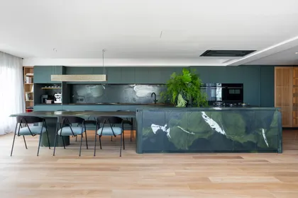 Cocina moderna con isla grande de mármol verde y gabinetes oscuros — proyecto Vidal, por Estudio Losa, en Belgrano
