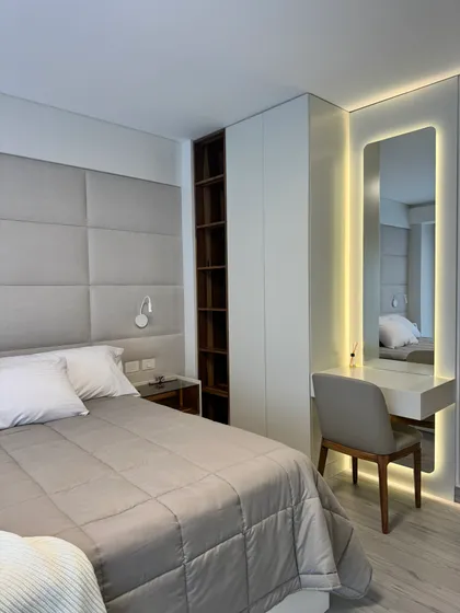 Dormitorio moderno con cama, escritorio, espejo y armario empotrado — proyecto Cerviño, por MDBK Arquitectura, en Palermo