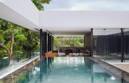 Piscina moderna de casa con sala integrada y vista al bosque — proyecto Casa em Curitiba , por Studio Guilherme Torres