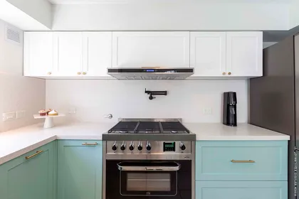 Cocina moderna blanca y verde con electrodomésticos de acero inoxidable — proyecto Proyecto Superí, por Estudio Equilibrio, en Belgrano