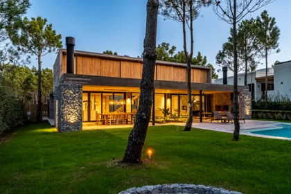 Casa moderna con piscina y jardín al atardecer — proyecto casa la huella, por Guerrero Arquitectos, en Pinamar