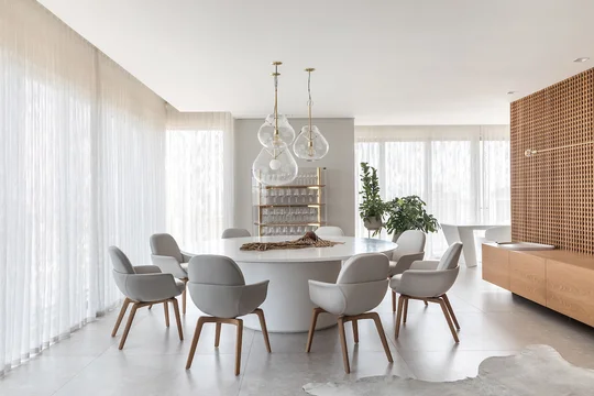 Living y comedor moderno con mesa redonda y sillas grises — proyecto Apto | EBS, por Claudia Vialle Arquitetura, en Caçador