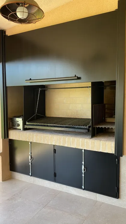 Área de quincho moderna con parrilla empotrada y gabinetes negros — proyecto Casa El Rebenque, por Arq. Leonardo De Lorenzi , en Canning