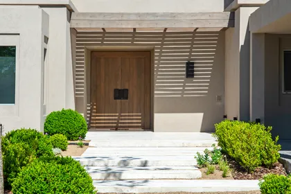 Fachada moderna con puertas de madera y detalles de listones de madera — proyecto Casa DF, por Estudio Junor, en Tigre