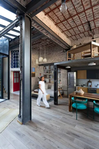 Loft industrial con doble altura y paredes de ladrillo expuesto — proyecto Casa Arcos, por Silvia Soqueff, en Núñez