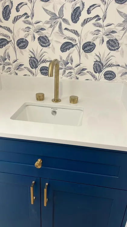 Baño moderno con tocador azul marino, encimera de mármol blanco y grifería de latón — proyecto CASA M, por Estudio Grupo 32, en Martínez