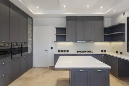 Cocina moderna gris con isla central y mesada blanca luminosa — proyecto El Golf 137 - Nordelta, por Build a Home Arquitectura, en B1624 Tigre