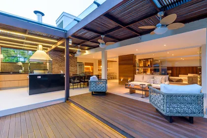 Galeria moderna con deck de madera, pergola y ventanal hacia interior — proyecto Casa De Praia, por Bordin E Soares Interiores