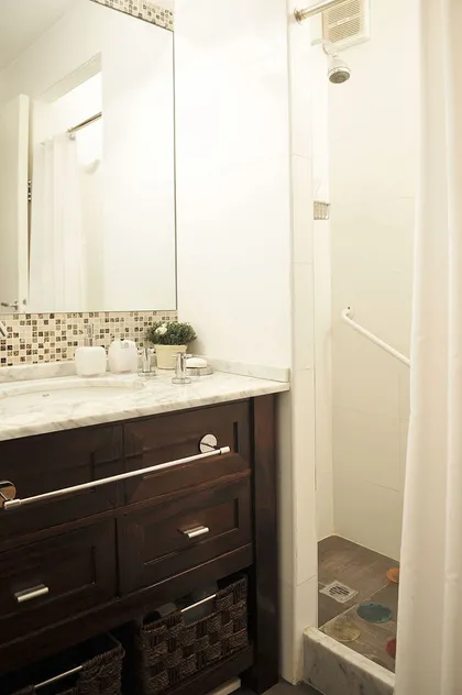 Baño moderno con vanitory oscuro, mesada mármol y espejo de marco plateado — proyecto Marcelo T de Alvear, por Rioja Arquitectura, en Recoleta