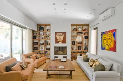 Living moderno con hogar, estanterías de madera y sofás curvos — proyecto Casa P, por Estudio Dado, en San Isidro