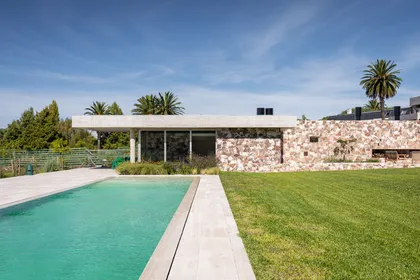 Casa moderna con piscina y fachada de piedra — proyecto Propiedad en Nordelta, por MARCO GUOLI PHOTO, en Nordelta