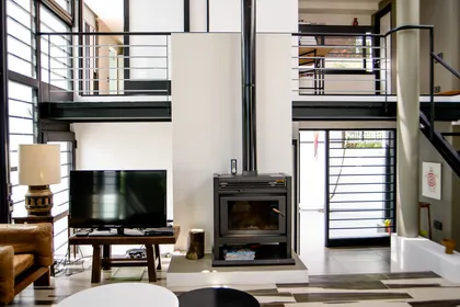 Living moderno con doble altura, hogar a leña y grandes ventanales — proyecto CASA GONNET, por LEONE LORAY ARQUITECTOS, en Gonnet