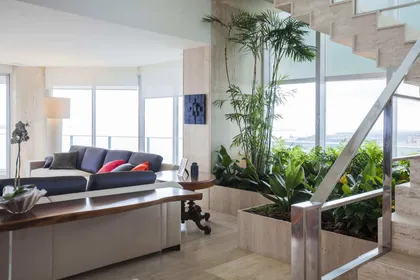 Living moderno con doble altura, jardin vertical y vistas amplias — proyecto Cobertura LS, por Patrícia Marinho Arquitetura