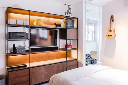 Dormitorio con mueble modular de madera y TV integrada — proyecto Cabrera, por Tali Estudio, en Palermo