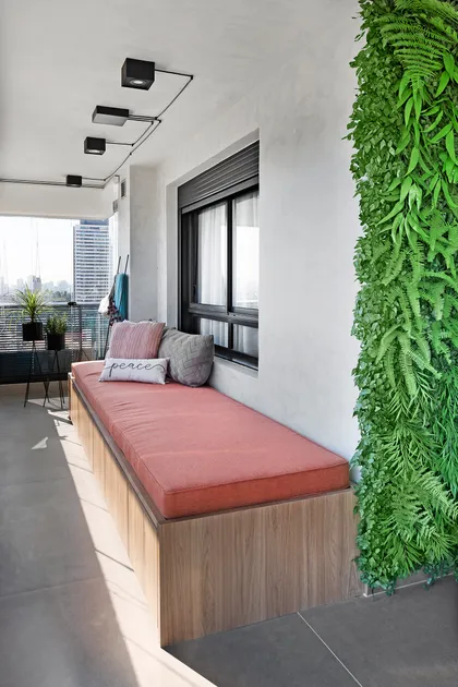 Balcón con banco integrado, pared verde y luces de riel — proyecto Benedito Pinheiros, por Bianchi E Lima
