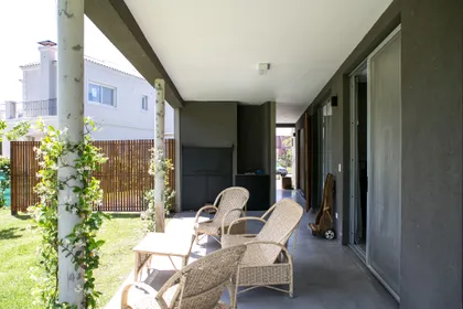 Terraza exterior moderna con pisos de hormigón y sillas de mimbre — proyecto Ayres Plaza C11, por ATO Arquitectos, en Ayres Plaza